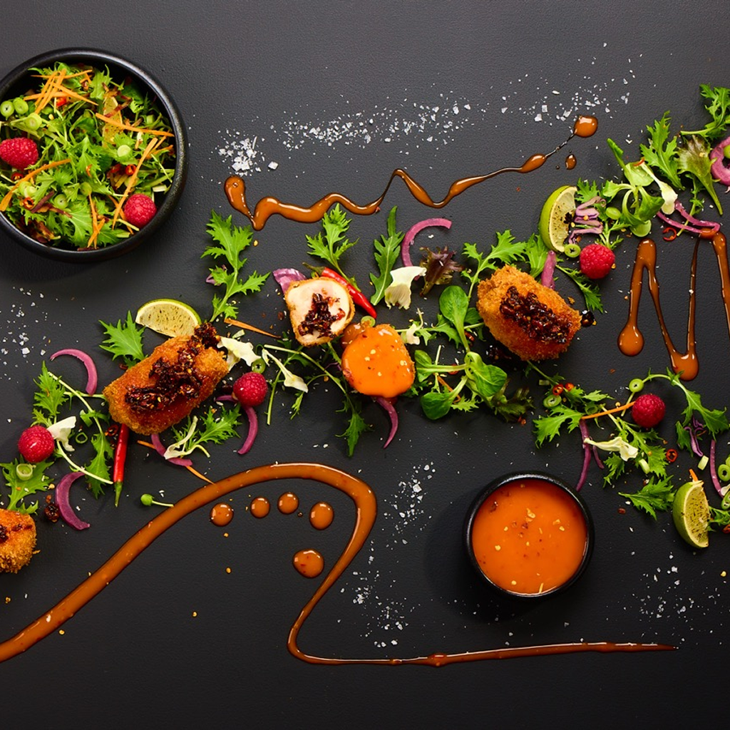 Knusprig gebackene Boneless Chicken Wings mit Zero Sweet & Chili Sauce und feinen Ringen von Frühlingslauch.